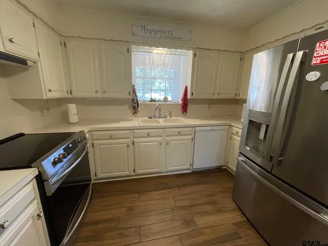 a kitchen with a sink a refrigerator and window