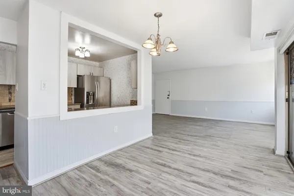 a view of a room with wooden floor and chandelier