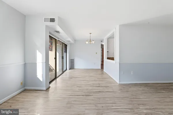 a view of a hallway with wooden floor and a bathroom