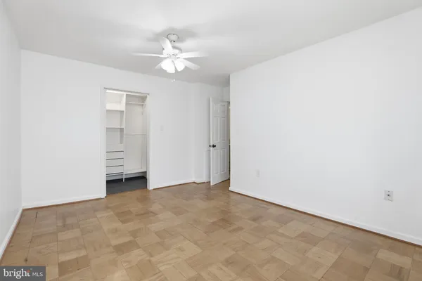 a view of an empty room with a chandelier fan