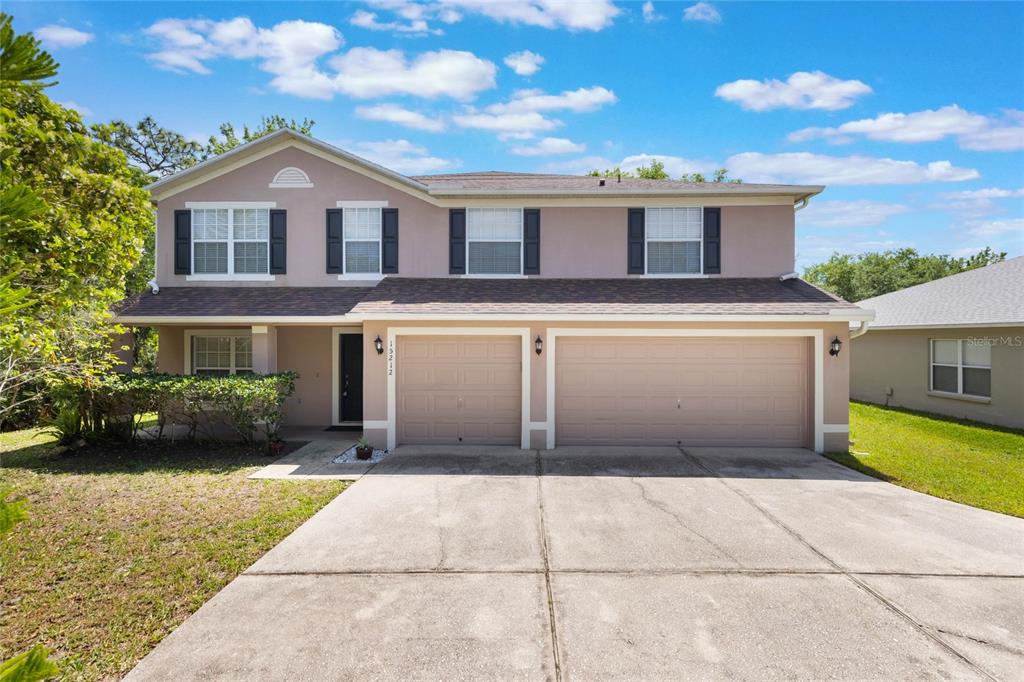 a front view of a house with a garden and trees