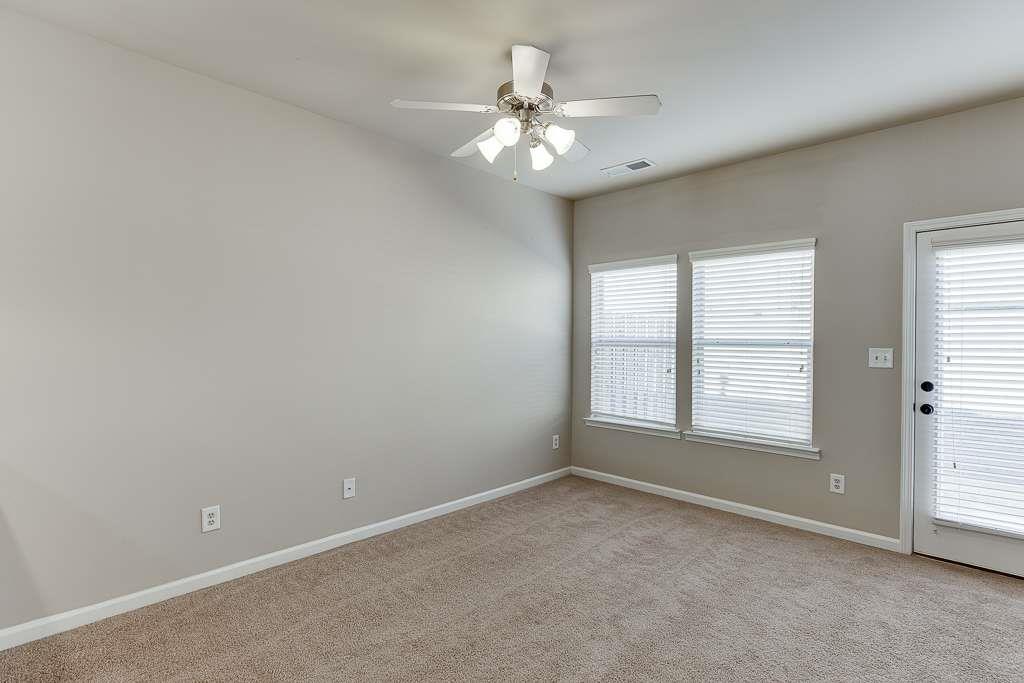 1043 Nightfall Court Northwest Suwanee, GA 30024 - Photo 13 of 39 an empty room with chandelier fan and windows