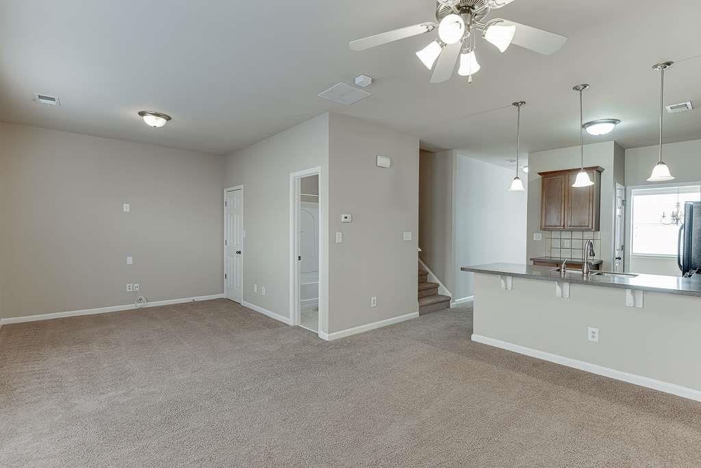 1043 Nightfall Court Northwest Suwanee, GA 30024 - Photo 15 of 39 an empty room with a kitchen and a chandelier fan