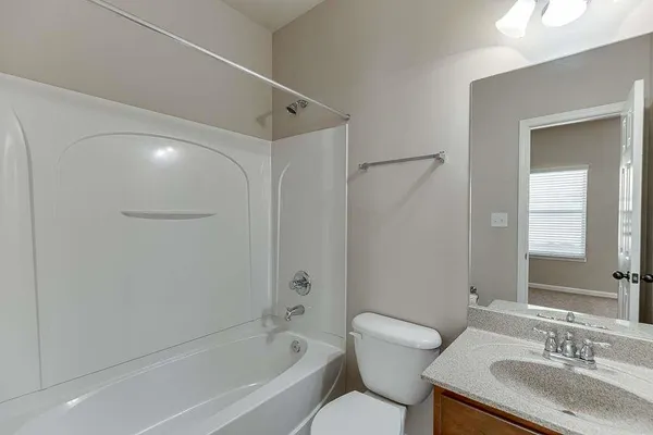 a bathroom with a granite countertop sink a toilet and shower