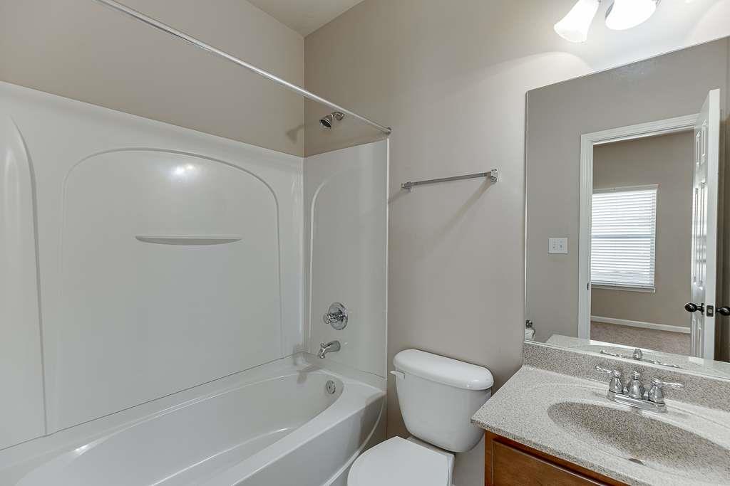 1043 Nightfall Court Northwest Suwanee, GA 30024 - Photo 17 of 39 a bathroom with a granite countertop sink a toilet and shower
