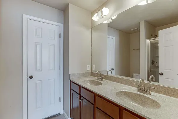 a bathroom with a granite countertop sink a mirror and a shower