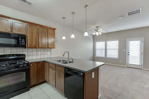 a kitchen that has a sink a stove and cabinets