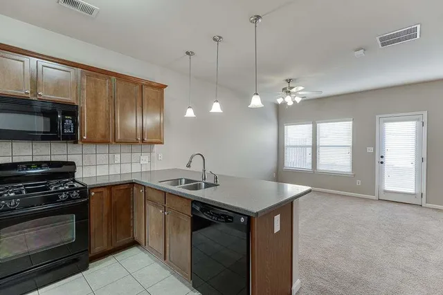 a kitchen that has a sink a stove and cabinets