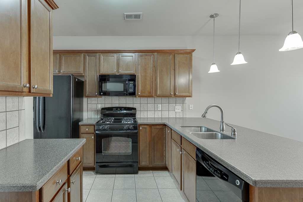 1043 Nightfall Court Northwest Suwanee, GA 30024 - Photo 9 of 39 a kitchen with a sink a stove and cabinets