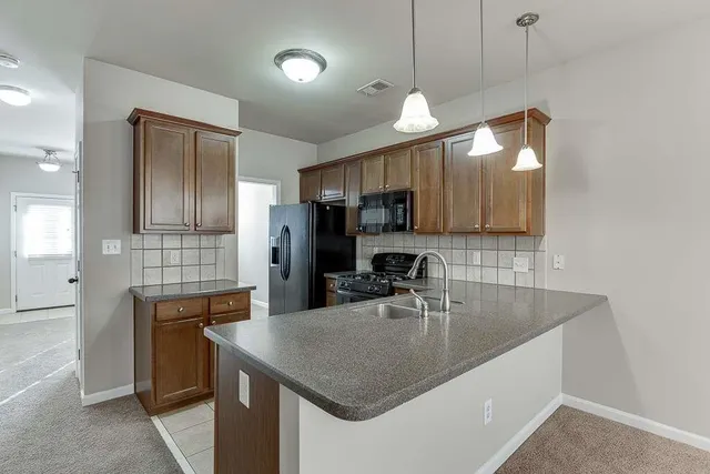 a kitchen with kitchen island a sink appliances and cabinets
