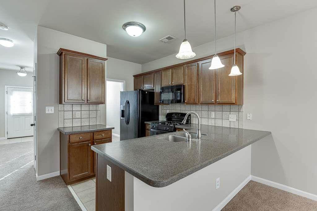 1043 Nightfall Court Northwest Suwanee, GA 30024 - Photo 10 of 39 a kitchen with kitchen island a sink appliances and cabinets