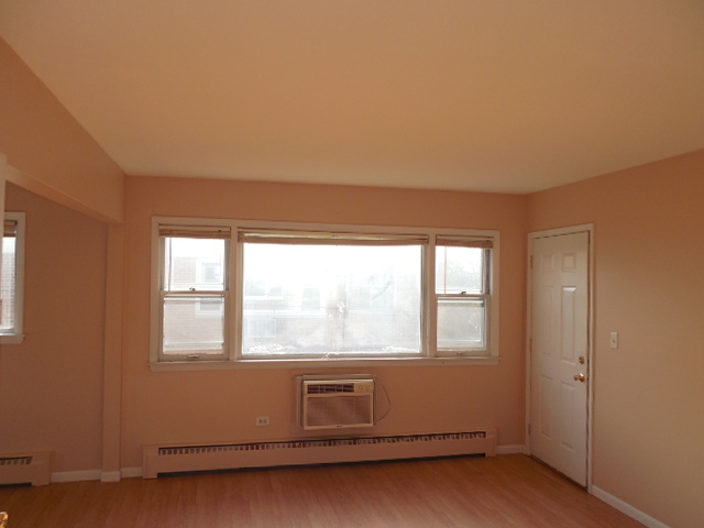 239 Northway Park Road, Unit 12 Machesney Park, IL 61115 - Photo 2 of 18 an empty room with wooden floor and windows