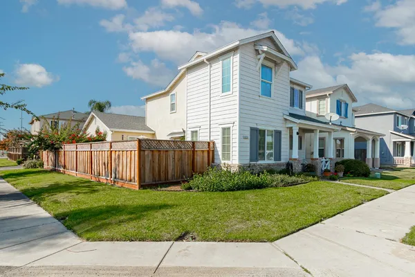 a view of a big house with a yard and plants