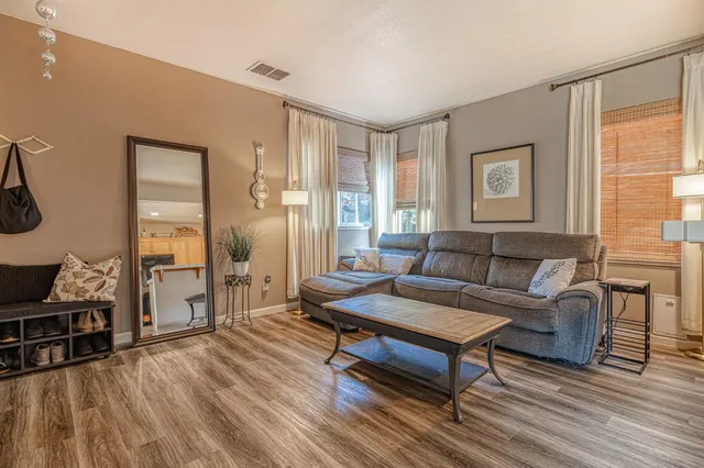 a living room with furniture and a wooden floor