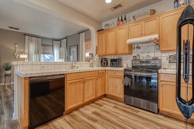 a kitchen with stainless steel appliances granite countertop a stove a sink and a microwave