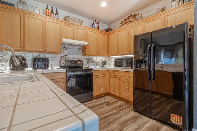 a kitchen with stainless steel appliances granite countertop a stove a sink and a refrigerator