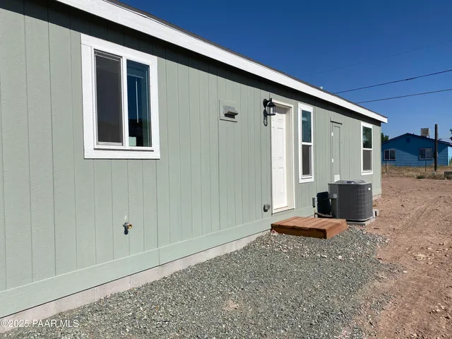 a backyard of a house with wooden floor and fence
