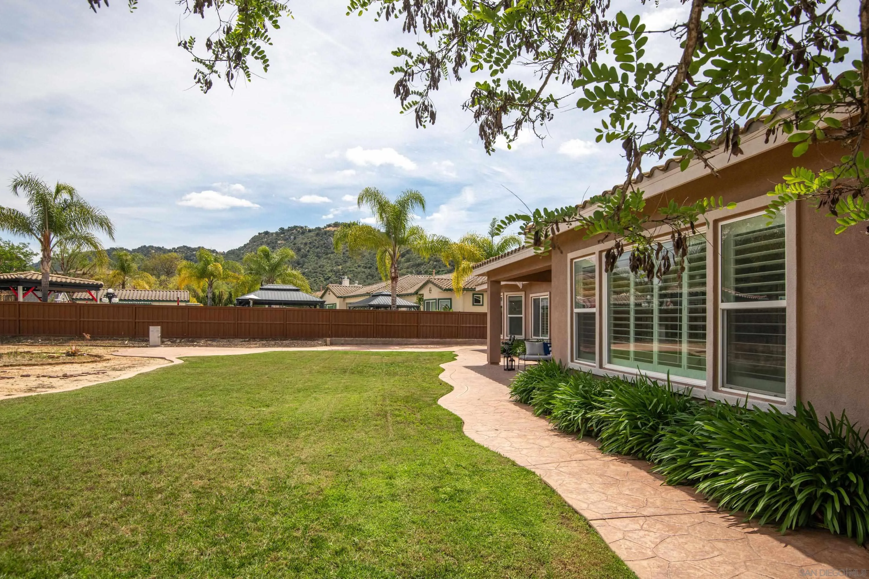 14220 Pebble Beach Way Valley Center, CA 92082 - Photo 32 of 48 a front view of a house with a yard and lake view