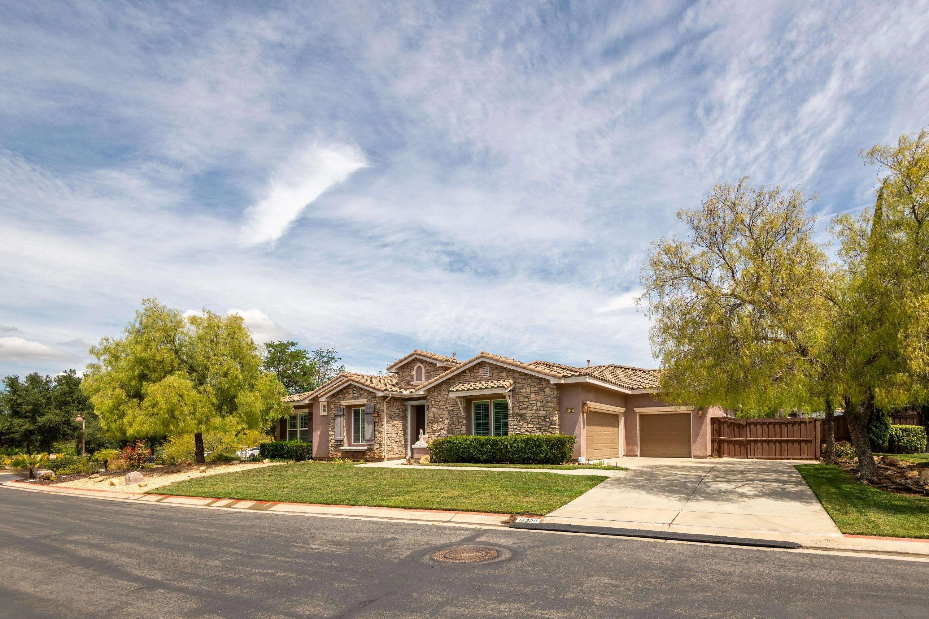 14220 Pebble Beach Way Valley Center, CA 92082 - Photo 38 of 48 a front view of a house with a yard and trees