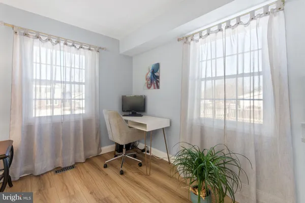 a view of a workspace with furniture and a window