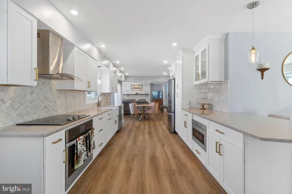 a large kitchen with stainless steel appliances granite countertop lots of counter top space and a sink