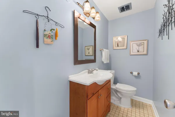 a bathroom with a sink vanity granite toilet and a mirror