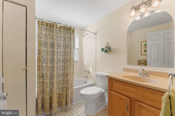 a bedroom with a bed chair and flat tv screen on the dresser