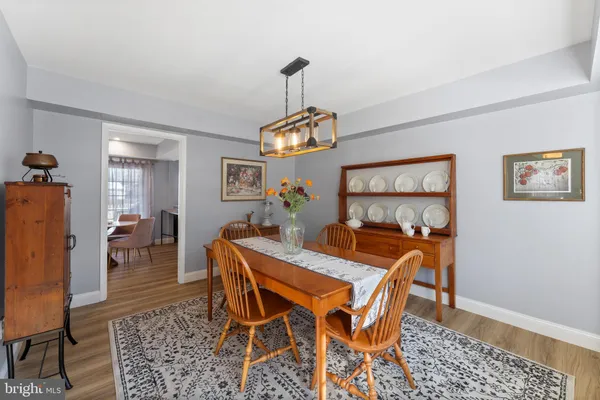 a view of a dining room and livingroom with furniture wooden floor a rug and a chandelier