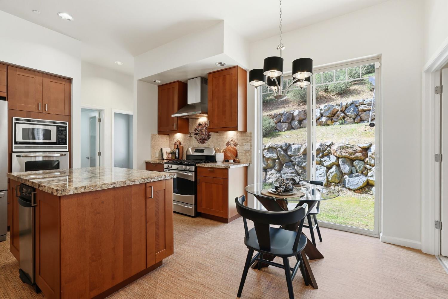 2213 Old Toll Road Placerville, CA 95667 - Photo 65 of 77 a kitchen with stainless steel appliances granite countertop a table chairs stove and refrigerator