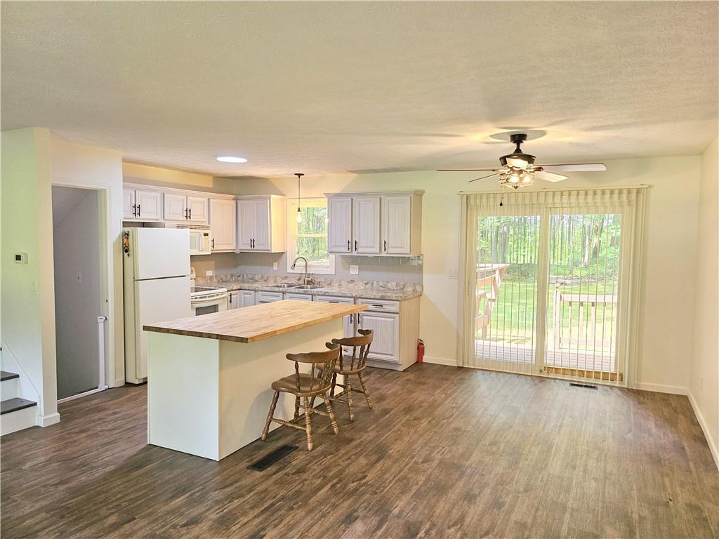 139 Sunset Road Grove City, PA 16127 - Photo 18 of 48 a kitchen with stainless steel appliances granite countertop a stove a refrigerator a sink a dining table and chairs with wooden floor