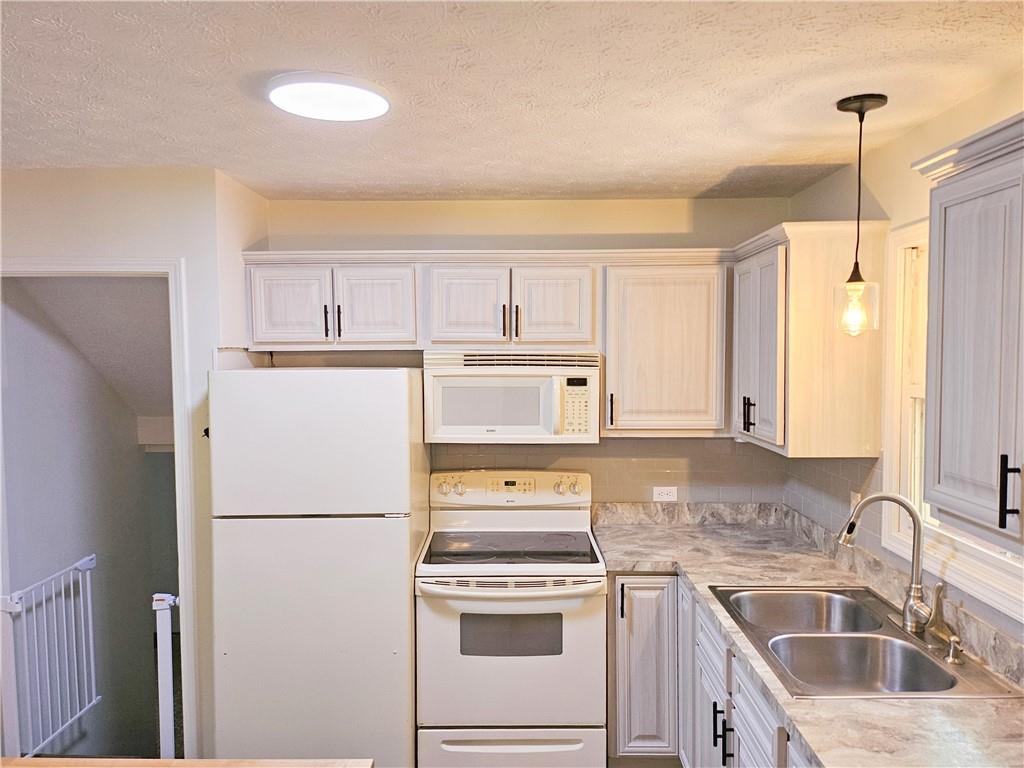 139 Sunset Road Grove City, PA 16127 - Photo 19 of 48 a kitchen with a refrigerator sink stove and cabinets