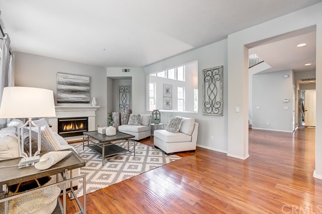 24 Silveroak Irvine, CA 92620 - Photo 14 of 49 a living room with furniture a fireplace and a wooden floor