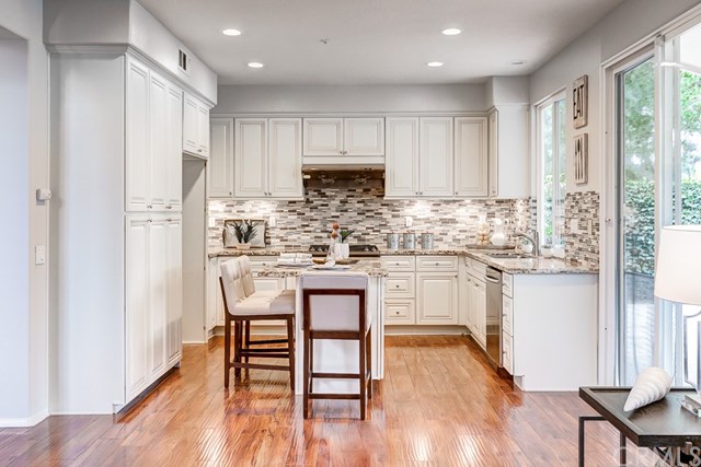 24 Silveroak Irvine, CA 92620 - Photo 18 of 49 a kitchen with stainless steel appliances granite countertop a white cabinets and wooden floor