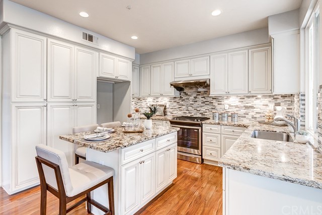24 Silveroak Irvine, CA 92620 - Photo 19 of 49 a kitchen with kitchen island granite countertop a sink stove and refrigerator