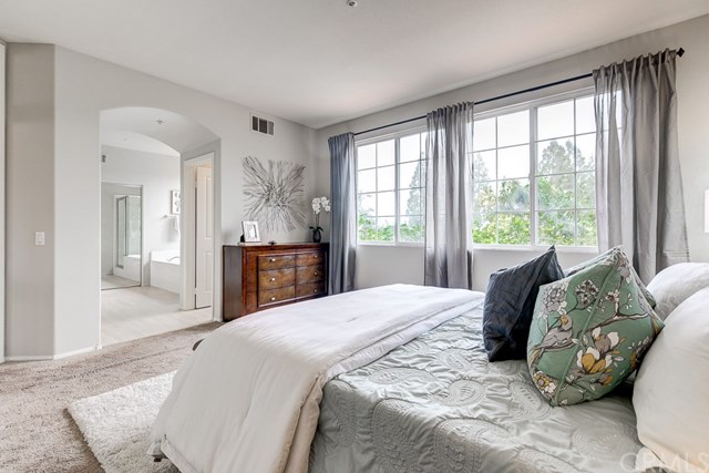24 Silveroak Irvine, CA 92620 - Photo 34 of 49 a bedroom with a bed and large windows