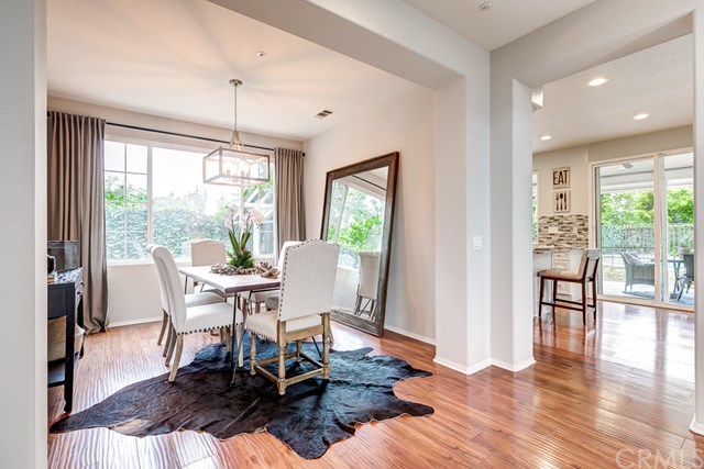 24 Silveroak Irvine, CA 92620 - Photo 10 of 49 a dining room with wooden floor a chandelier a glass table and chairs