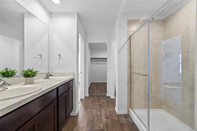 a bathroom with a granite countertop sink a mirror and a shower