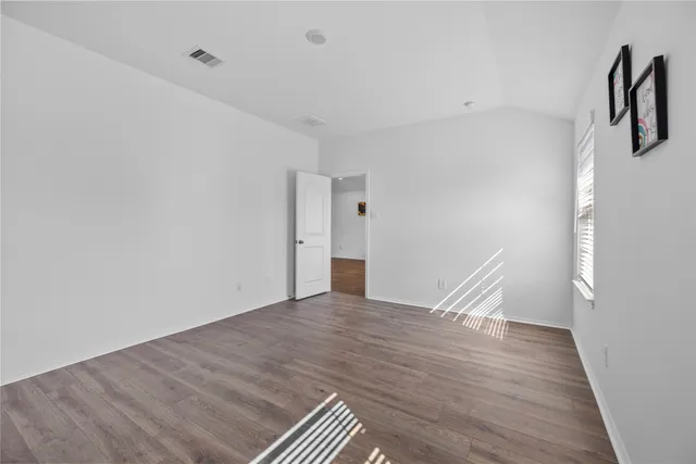 a view of a room with wooden floor and white walls