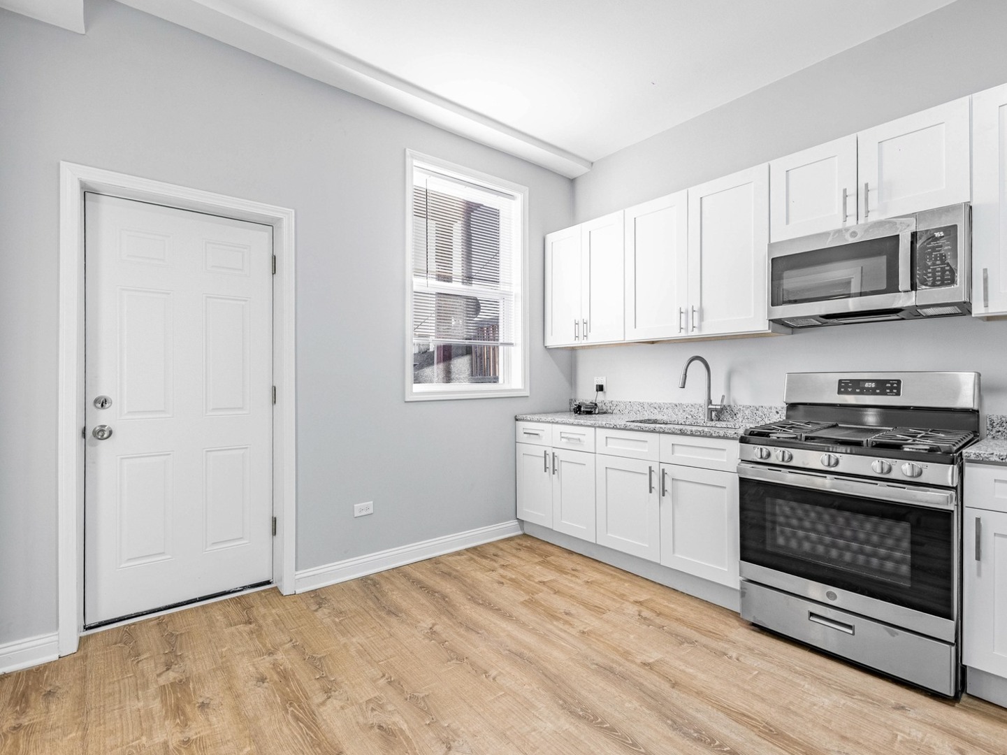 1621 West Cullerton Street, Unit 2 Chicago, IL 60608 - Photo 6 of 17 a kitchen with stainless steel appliances granite countertop a stove top oven a sink dishwasher and a refrigerator with wooden floor