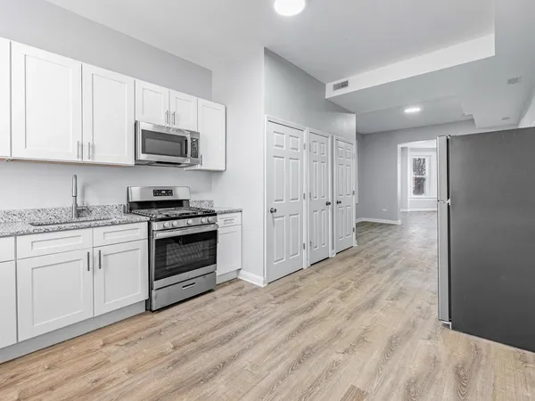a kitchen with stainless steel appliances granite countertop a stove a sink and a refrigerator