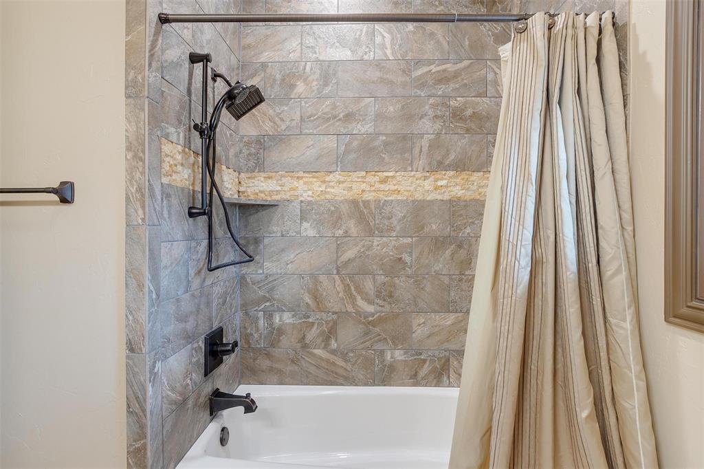9310 Bellechase Road Granbury, TX 76049 - Photo 20 of 39 a bath tub sitting next to a white sink and a shower