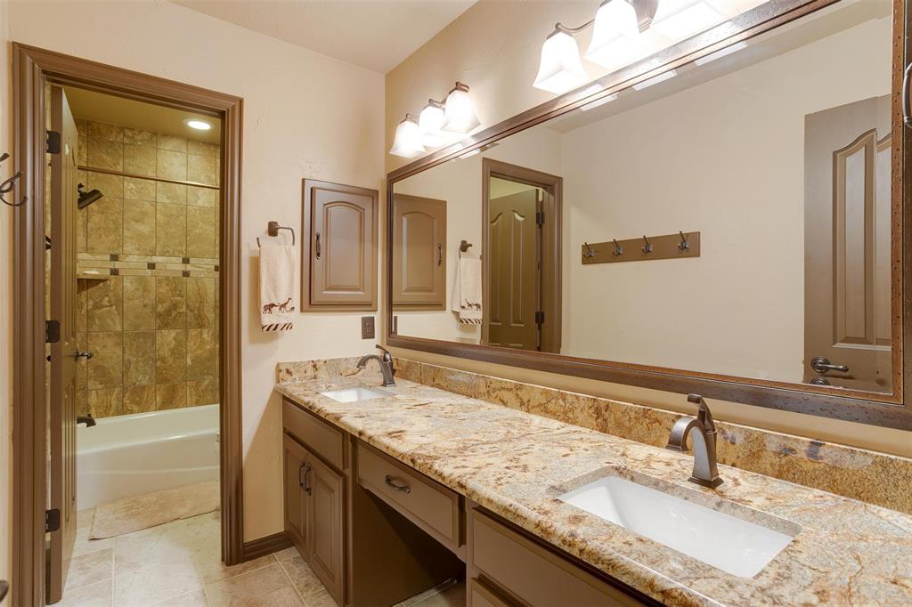 9310 Bellechase Road Granbury, TX 76049 - Photo 28 of 39 a bathroom with a granite countertop sink and a mirror