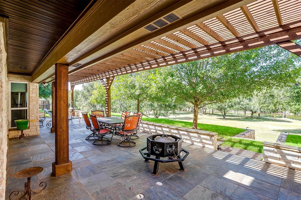 9310 Bellechase Road Granbury, TX 76049 - Photo 37 of 39 a view of a patio with table and chairs potted plants with wooden floor and fence