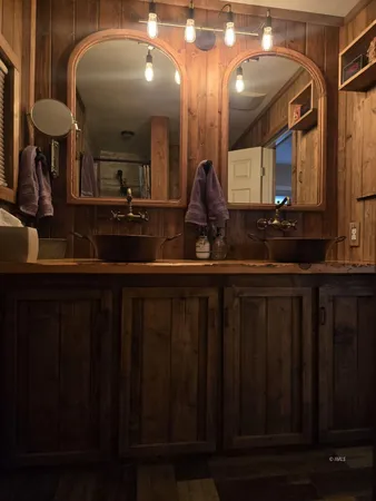 a bathroom with double vanity and a mirror