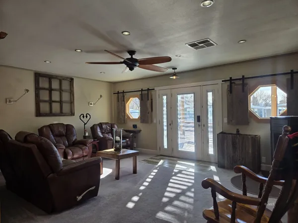 a living room with furniture a large window and a chandelier