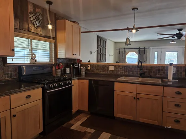 a kitchen with granite countertop a sink cabinets and stainless steel appliances