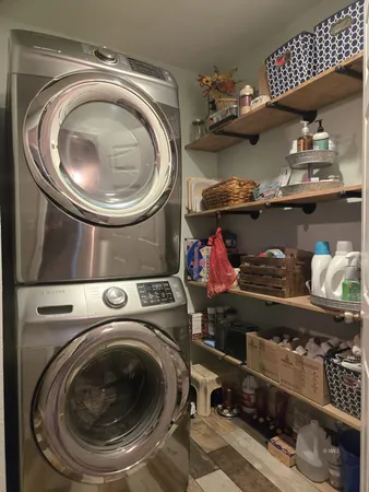 a utility room with lots of clutter and stainless steel appliances