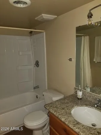 a bathroom with a granite countertop sink toilet and shower