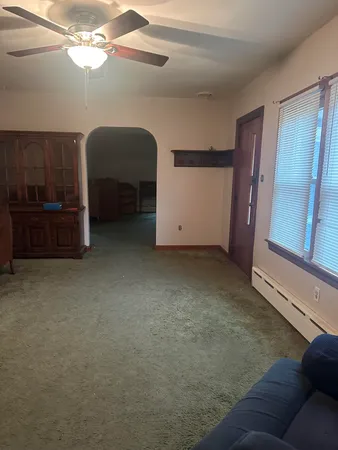 a view of an empty room and chandelier fan