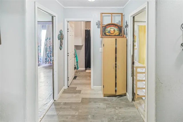 a view of a hallway with wooden floor and a dining room